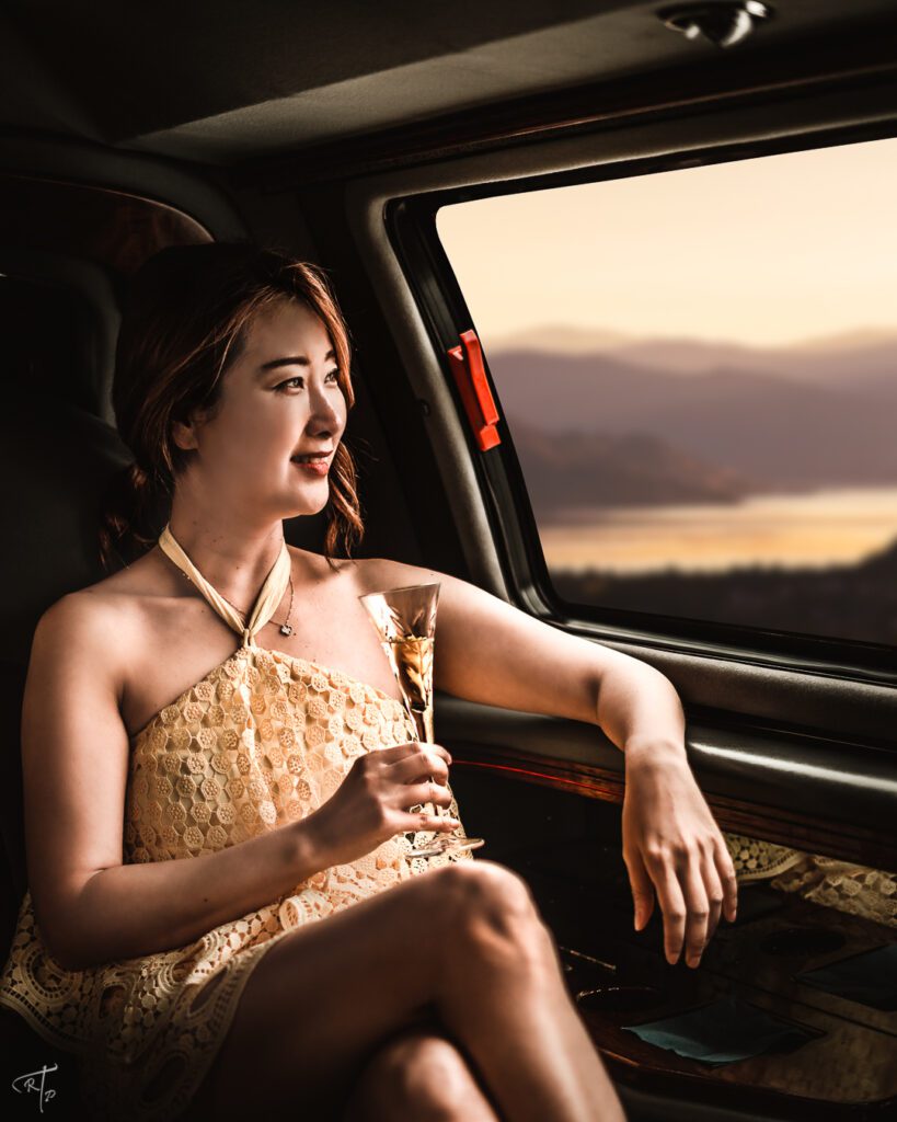 Jiyoung looking out the Window of SUV holding a glass of champagne