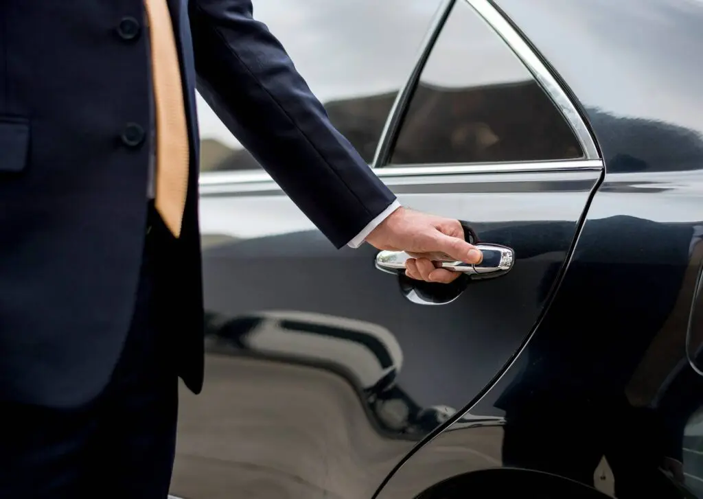 kelowna chauffeur preparing to open door on black luxury vehicle